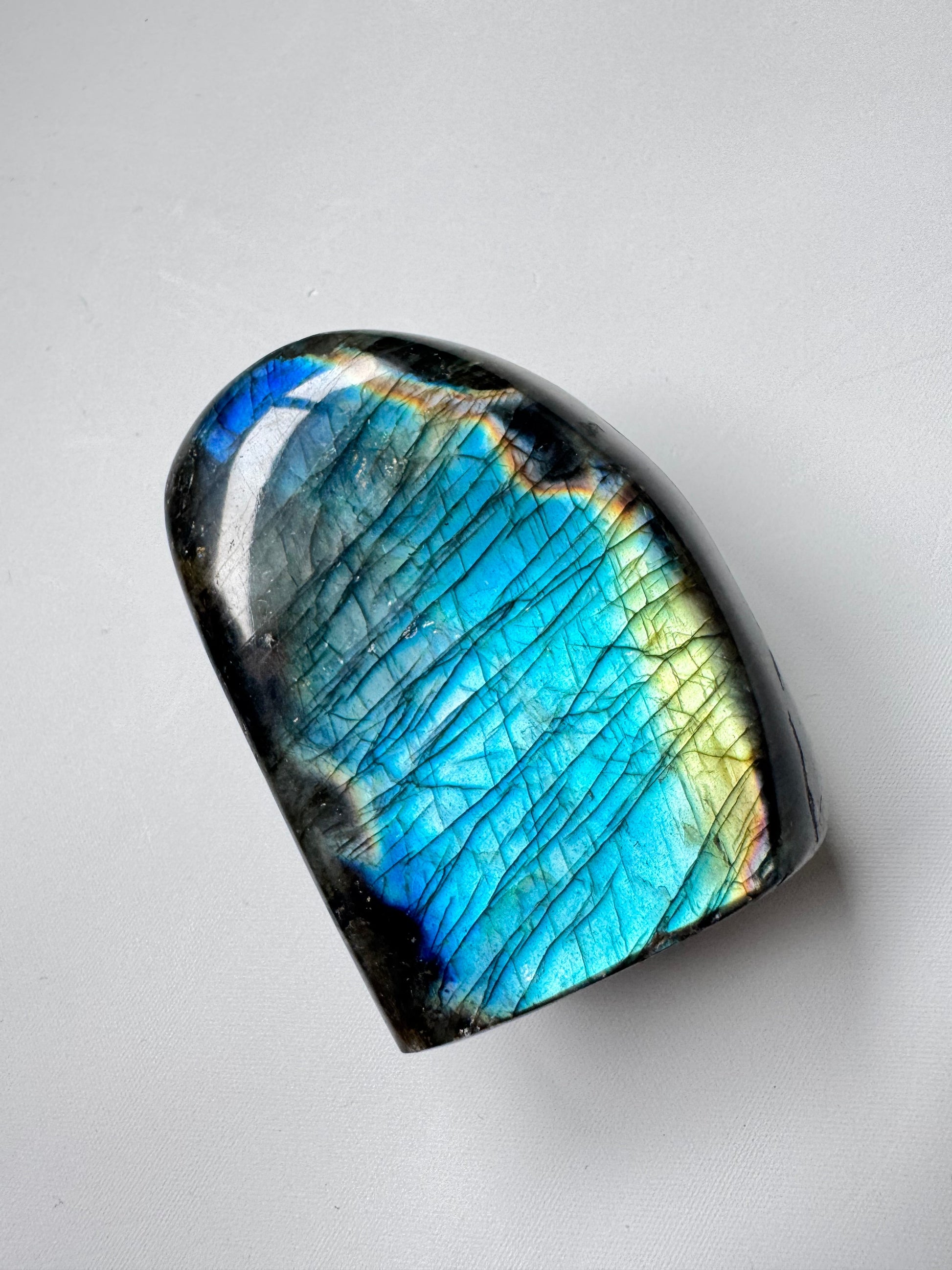 HQ Labradorite Crystal Freeform A01 showcases vibrant peacock blues and golden flashes, ideal for collectors of bespoke crystals and metaphysical decor.