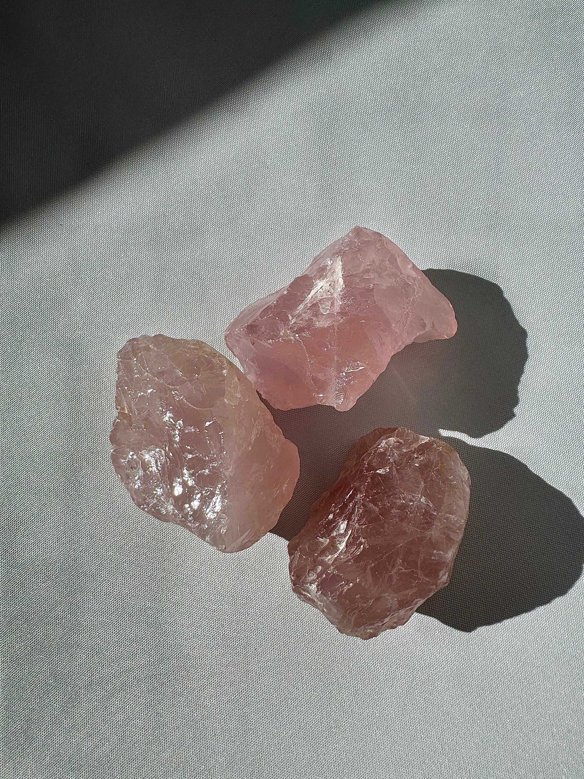 Three raw rose quartz crystal pieces with a soft pink hue, showcasing natural texture and clarity | Bespoke Crystals |  Ideal for collectors and crystal healing.