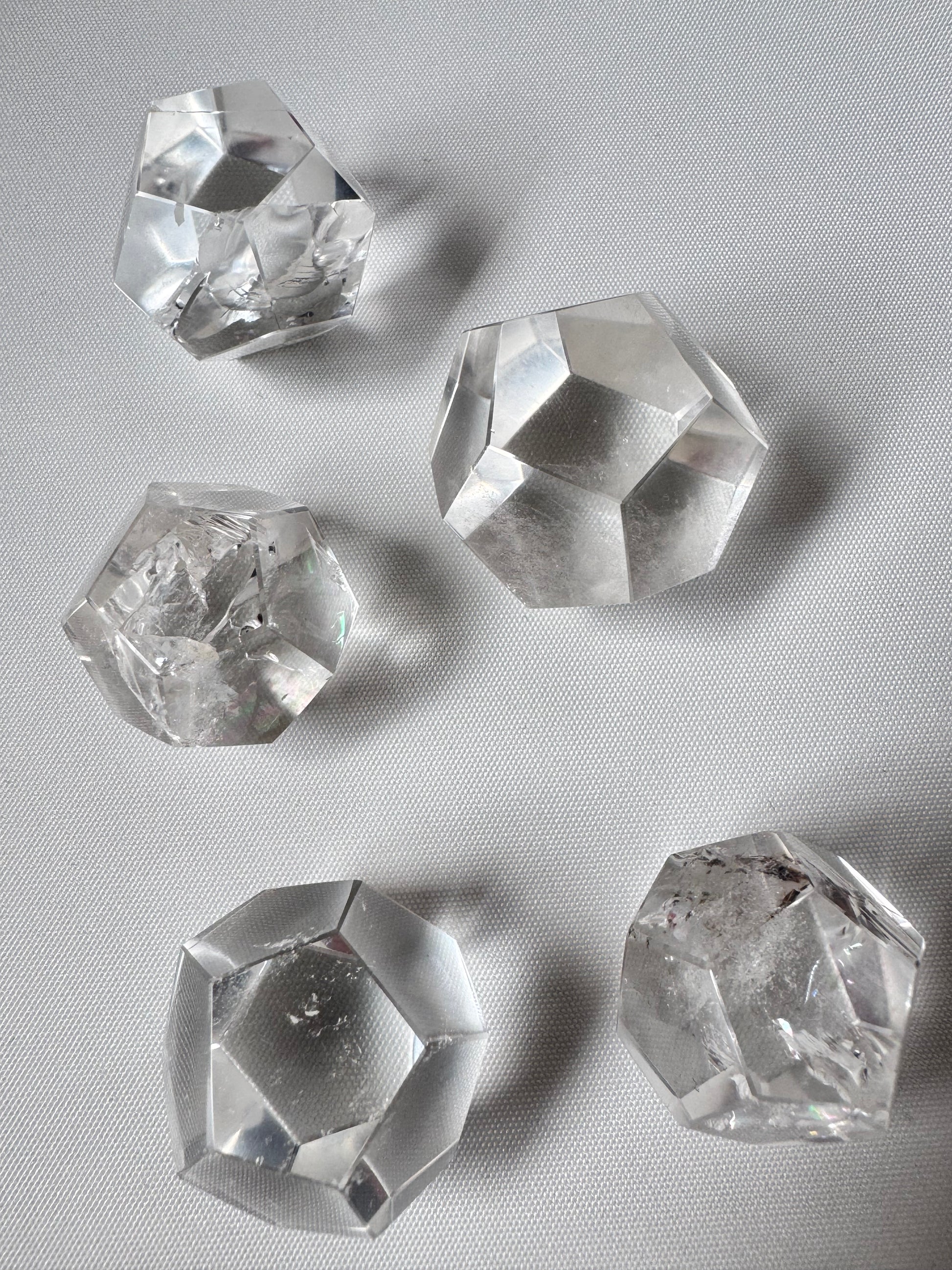 Lemurian Crystal Dodecahedron Set featuring five polished quartz shapes for meditation and energy work, displayed on a white surface.