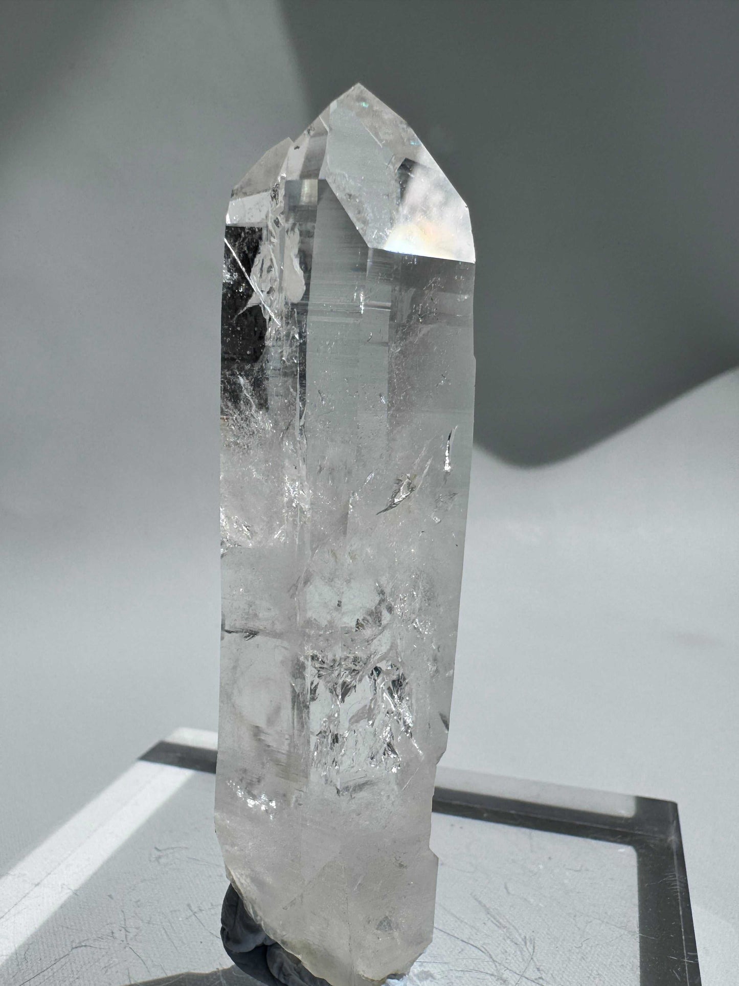 Polished Silver Light Lemurian Seed Crystal Wand standing upright, showcasing clear quartz clarity and natural inclusions for collectors.