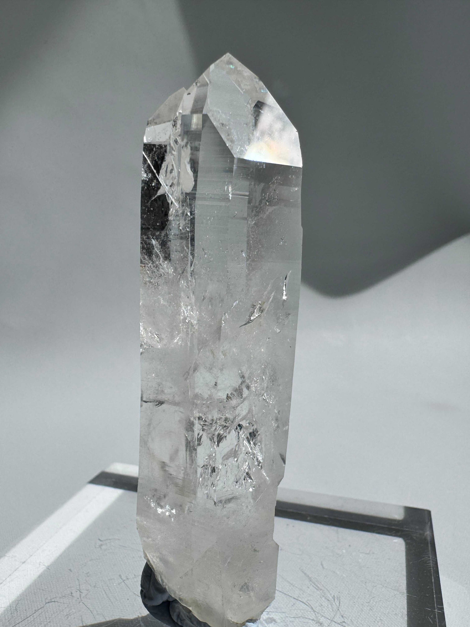 Polished Silver Light Lemurian Seed Crystal Wand standing upright, showcasing clear quartz clarity and natural inclusions for collectors.