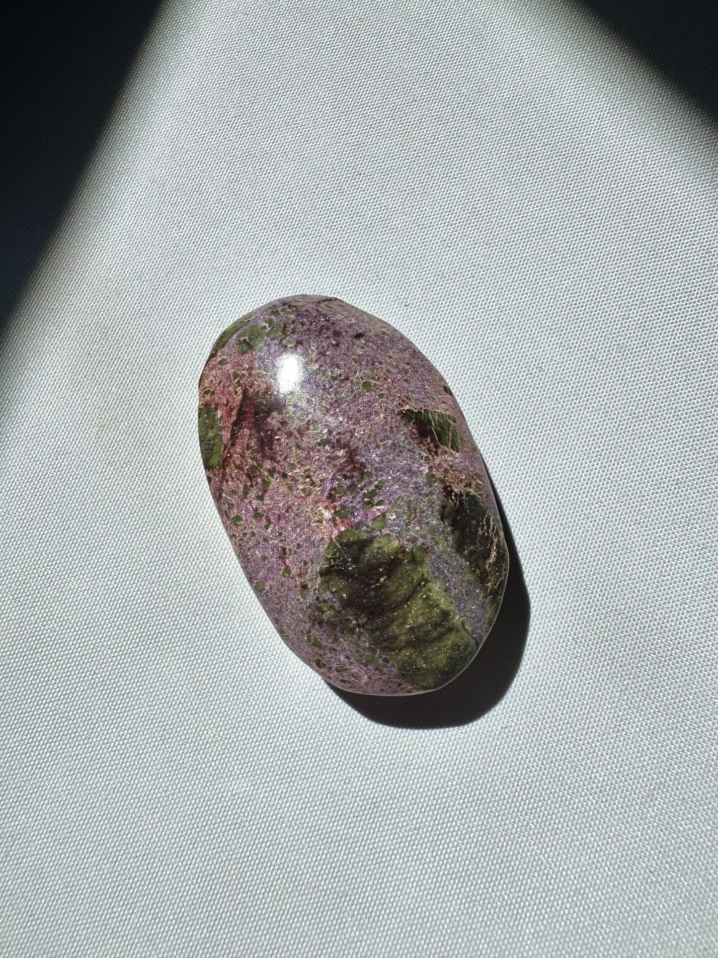 Compact Atlantisite Crystal Palm Stone with speckled purple and green surface, a bespoke crystal for emotional healing.