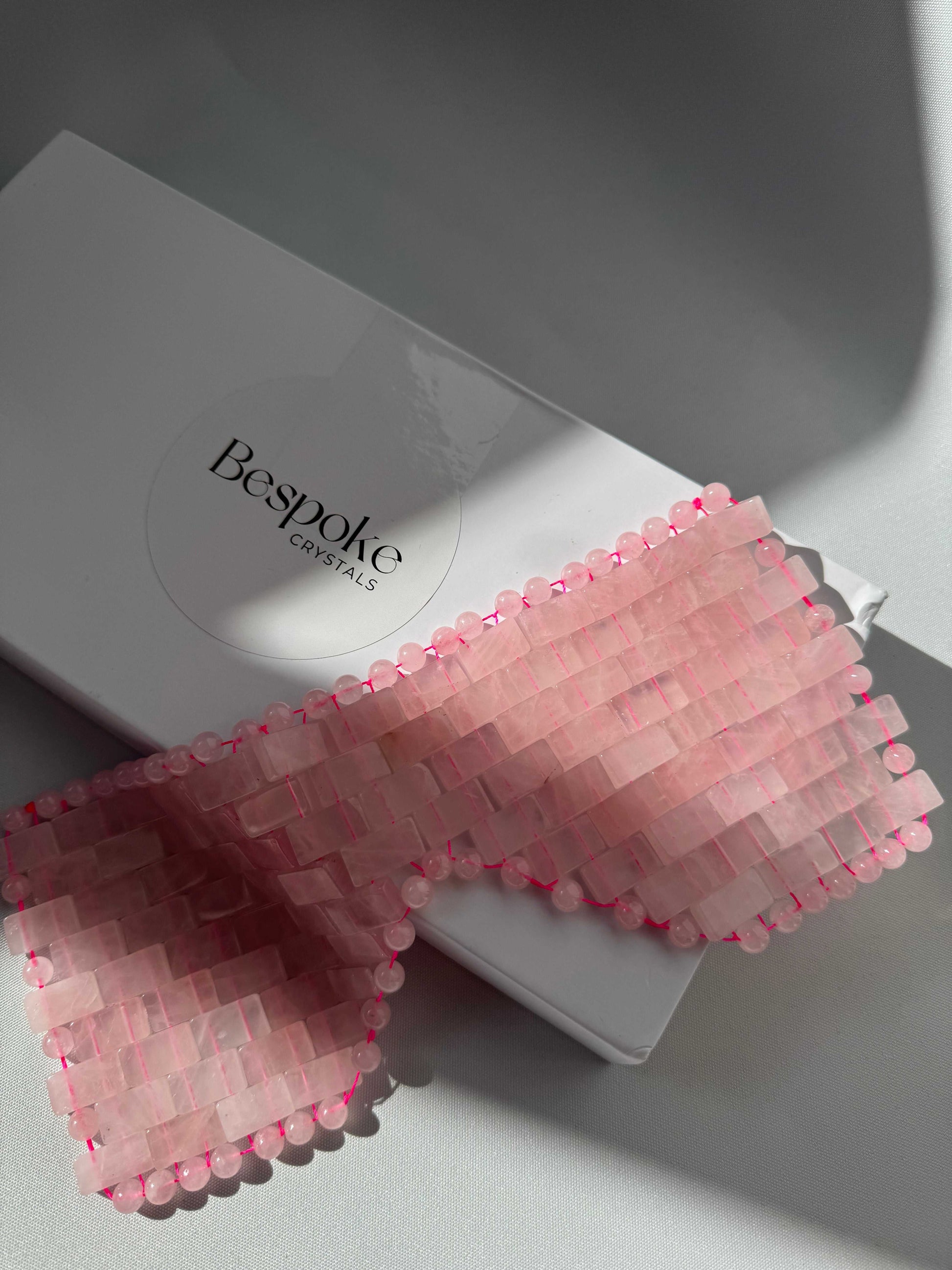 Rose Quartz Crystal Eye Mask by Bespoke Crystals displayed on branded packaging. Ideal for soothing skin and reducing puffiness naturally.