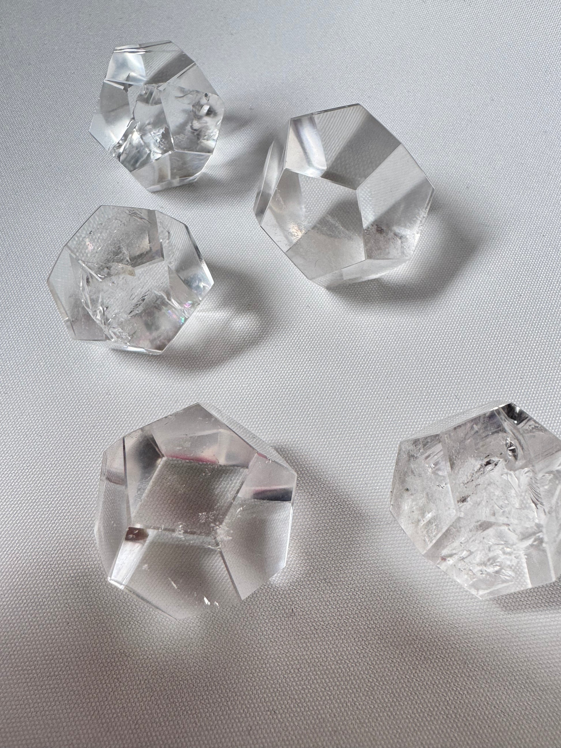 Lemurian Crystal Dodecahedron Set of five clear quartz geometric solids arranged diagonally, ideal for spiritual and energy practices.