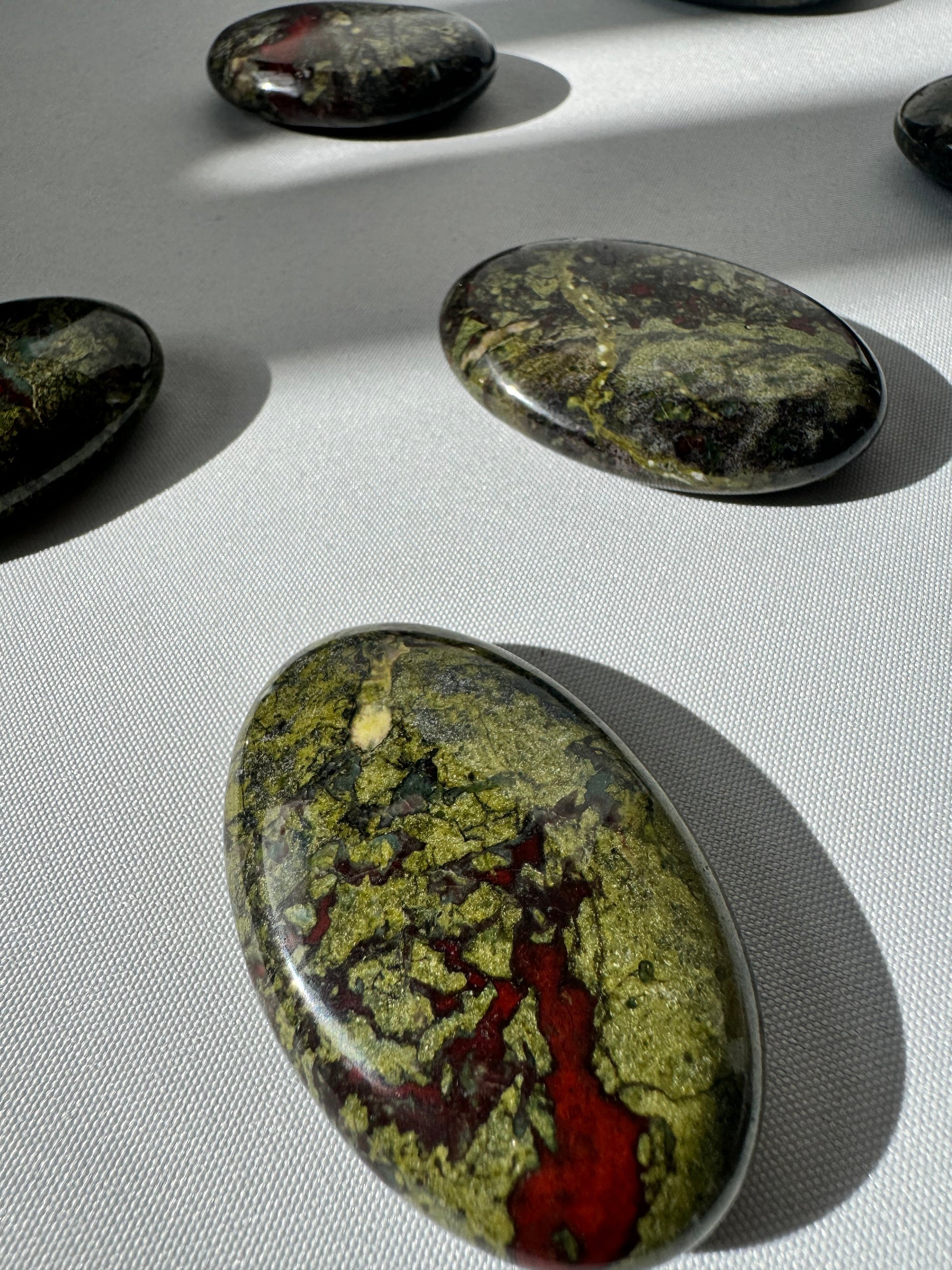 Dragon Stone Crystal Palm Stone with vivid red and green hues, polished for grounding and vitality. Ideal for collectors of bespoke crystals.