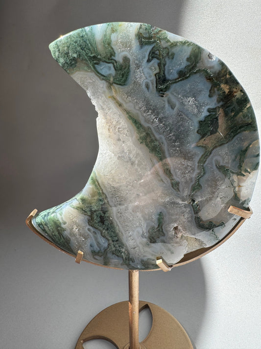 Close-up of Moss Agate Crystal Moon on Stand #1 with detailed green moss-like inclusions and sparkling druzy, ideal for crystal collectors.