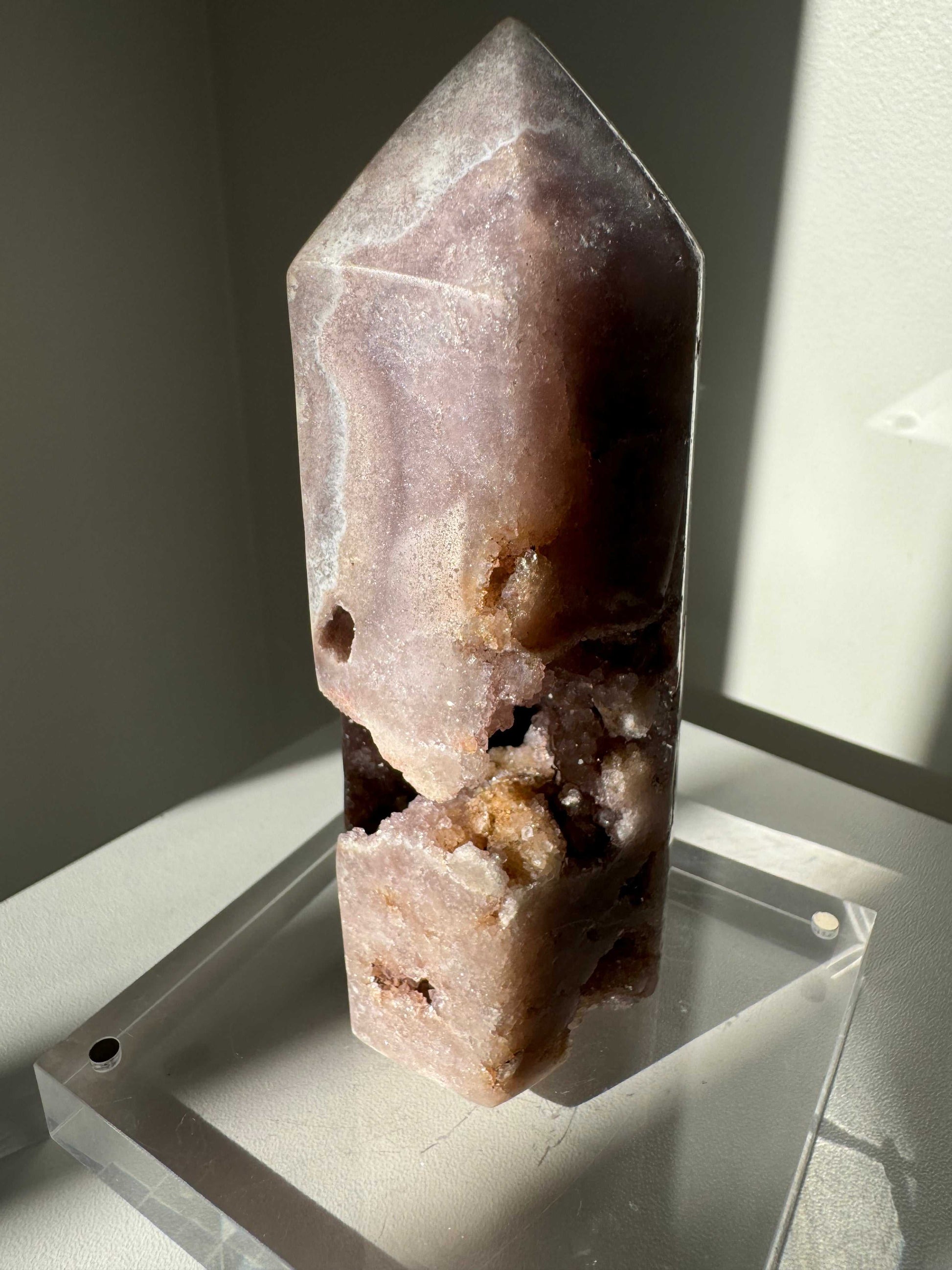 Pink Amethyst Tower with visible druzy clusters and soft pink hues, placed on clear display stand. Enhances any crystal or fossil collection.