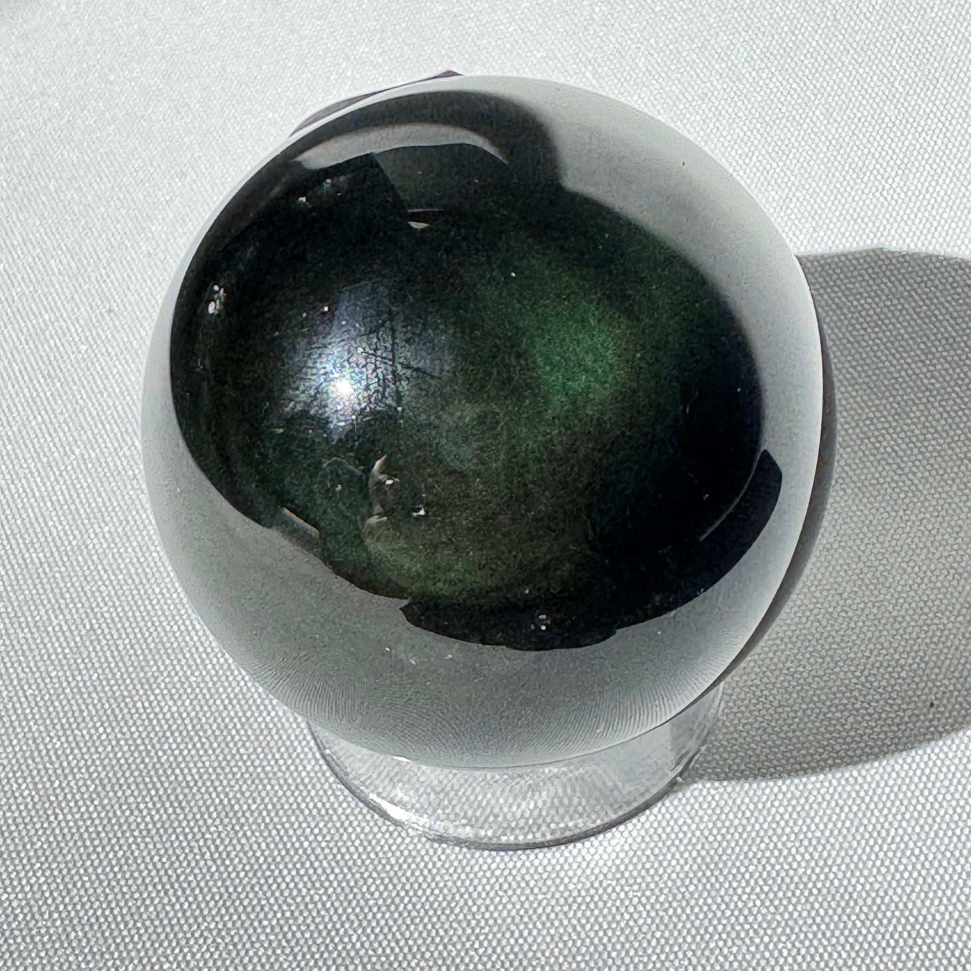 Polished Rainbow Obsidian Sphere Healing Crystal showing deep green hues. Used for emotional growth, energy work, and Halloween-themed decor.
