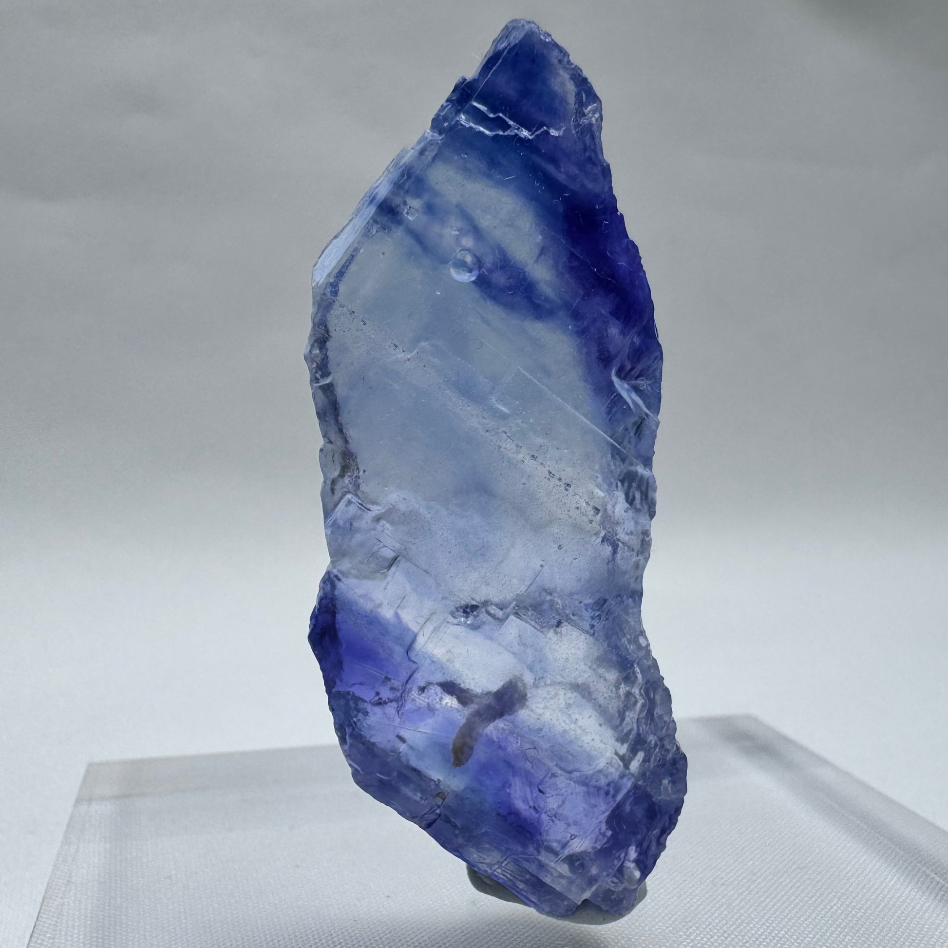 Elongated Blue Halite crystal with icy blue and violet streaks, a rare and visually stunning mineral for collectors.