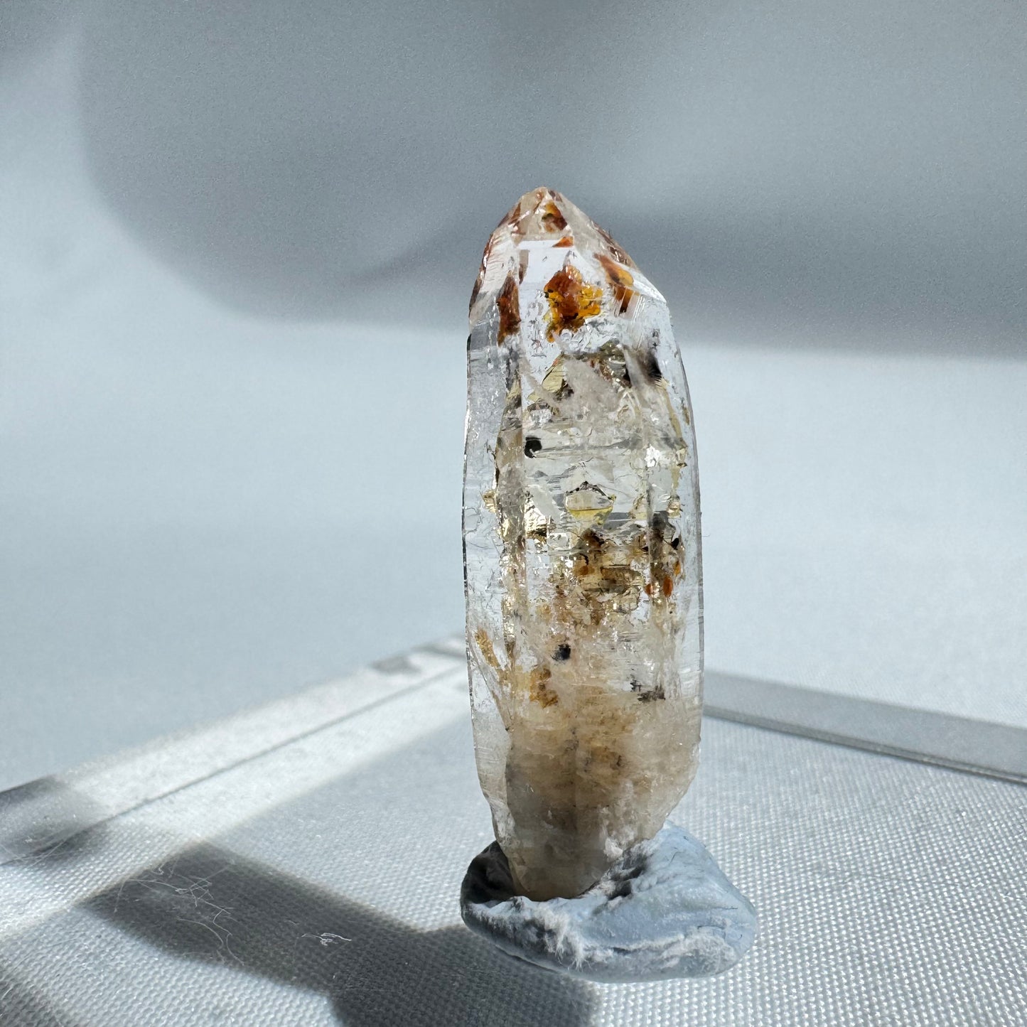 Pointed UV Reactive Firefly Enhydro Quartz crystal featuring vibrant petroleum inclusions, perfect for gemstone enthusiasts.