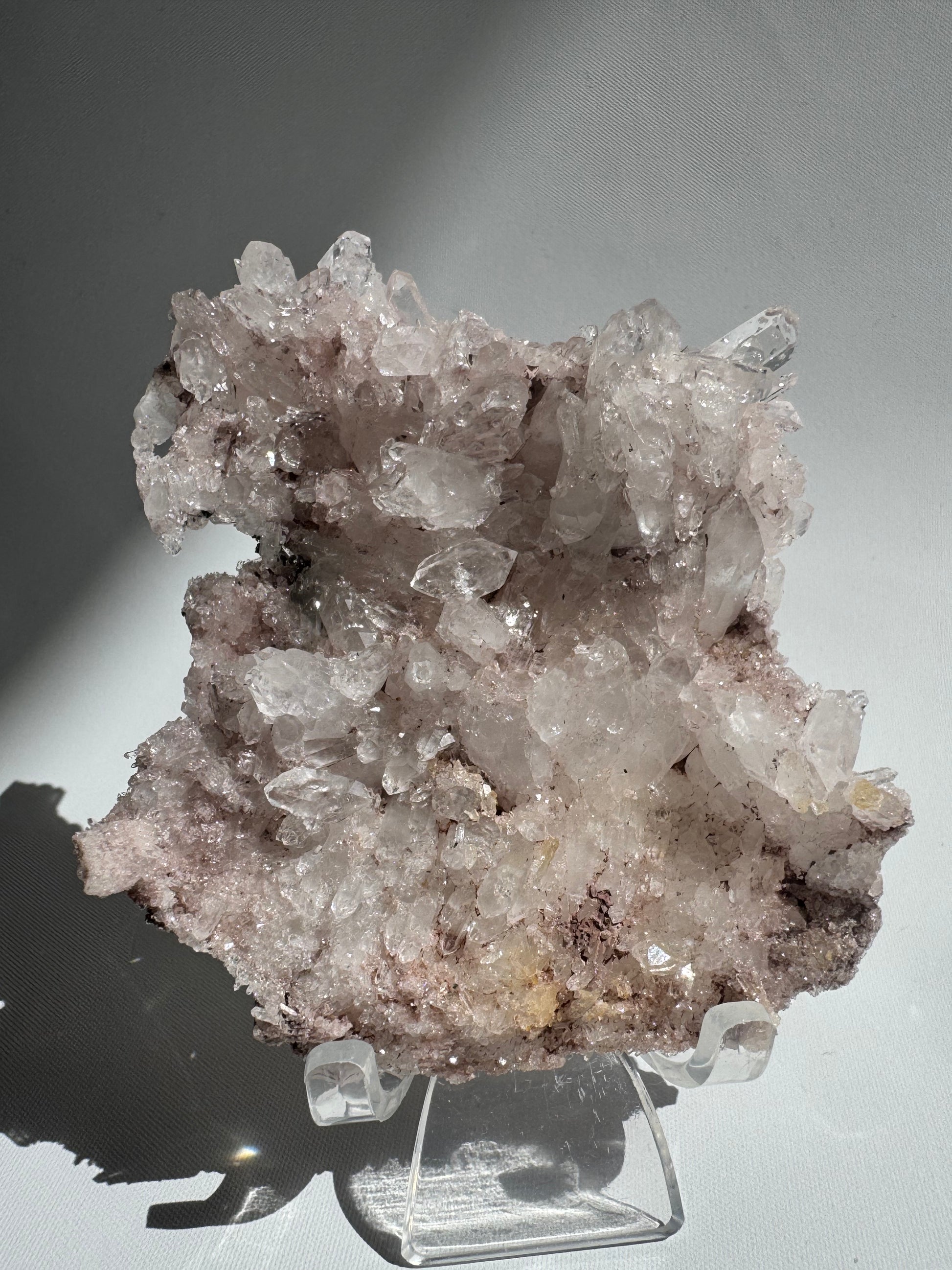 Colombian Pink Lithium Lemurian Quartz Cluster sparkling under natural light, showcasing its calming energy and collectible crystal structure.