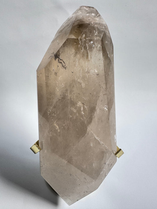 Large Natural Citrine Freeform Crystal from Brazil displayed upright on a gold stand, showcasing its faceted clarity and warm golden tones.