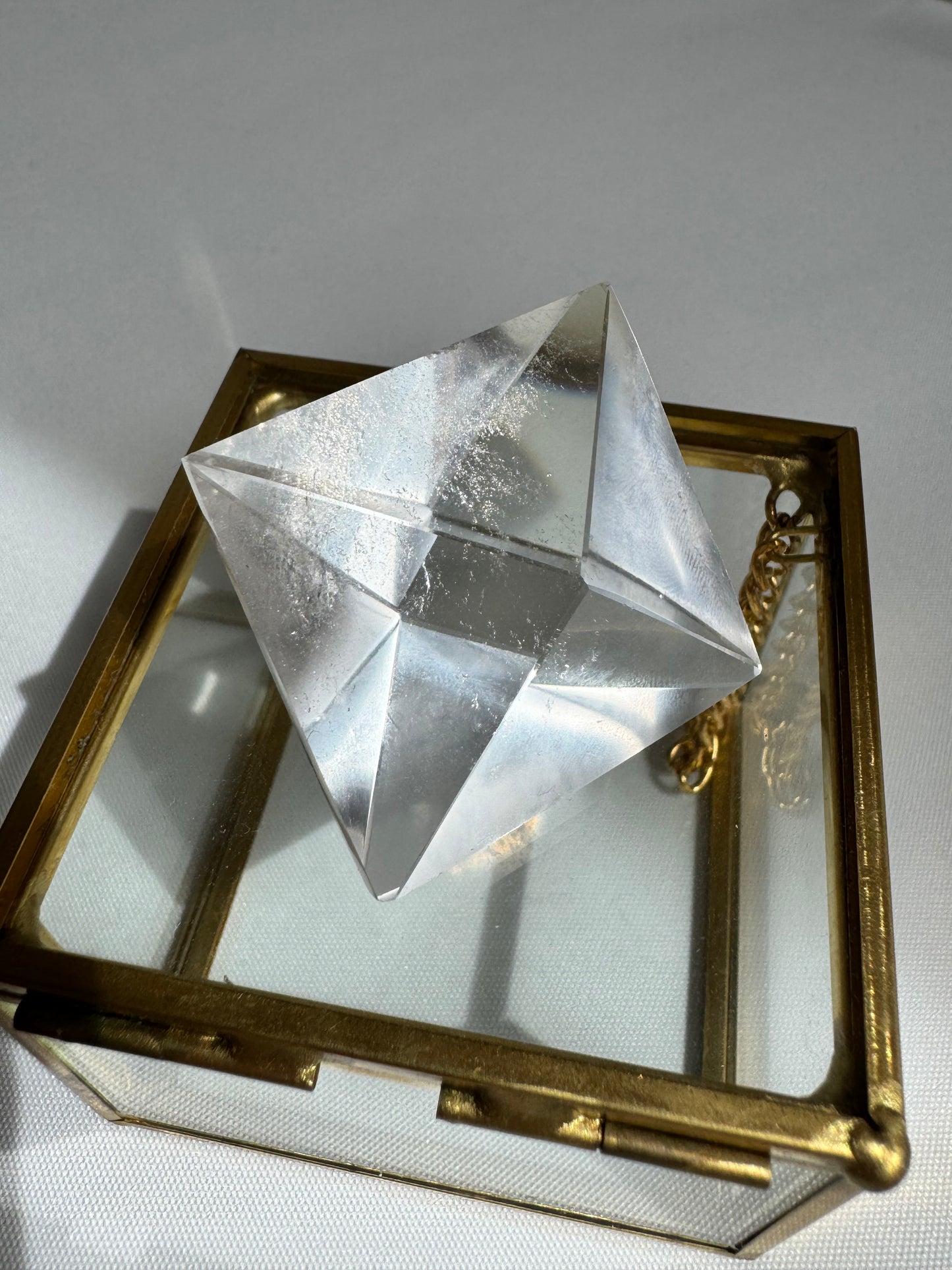 Transparent Lemurian Quartz Octahedron on display box, used for energy focus, meditation, and spiritual transformation.