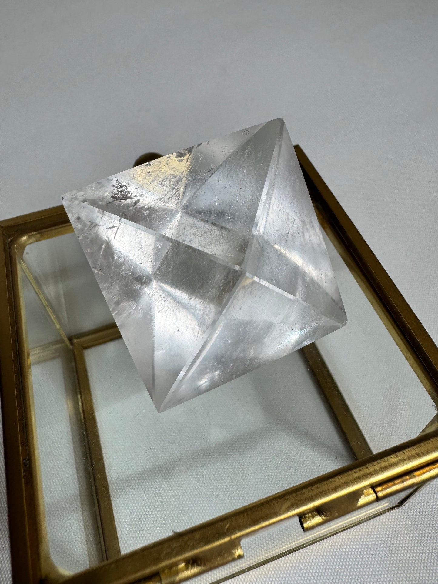 Large Lemurian Quartz Octahedron on glass box, perfect for energy healing and sacred geometry practices.