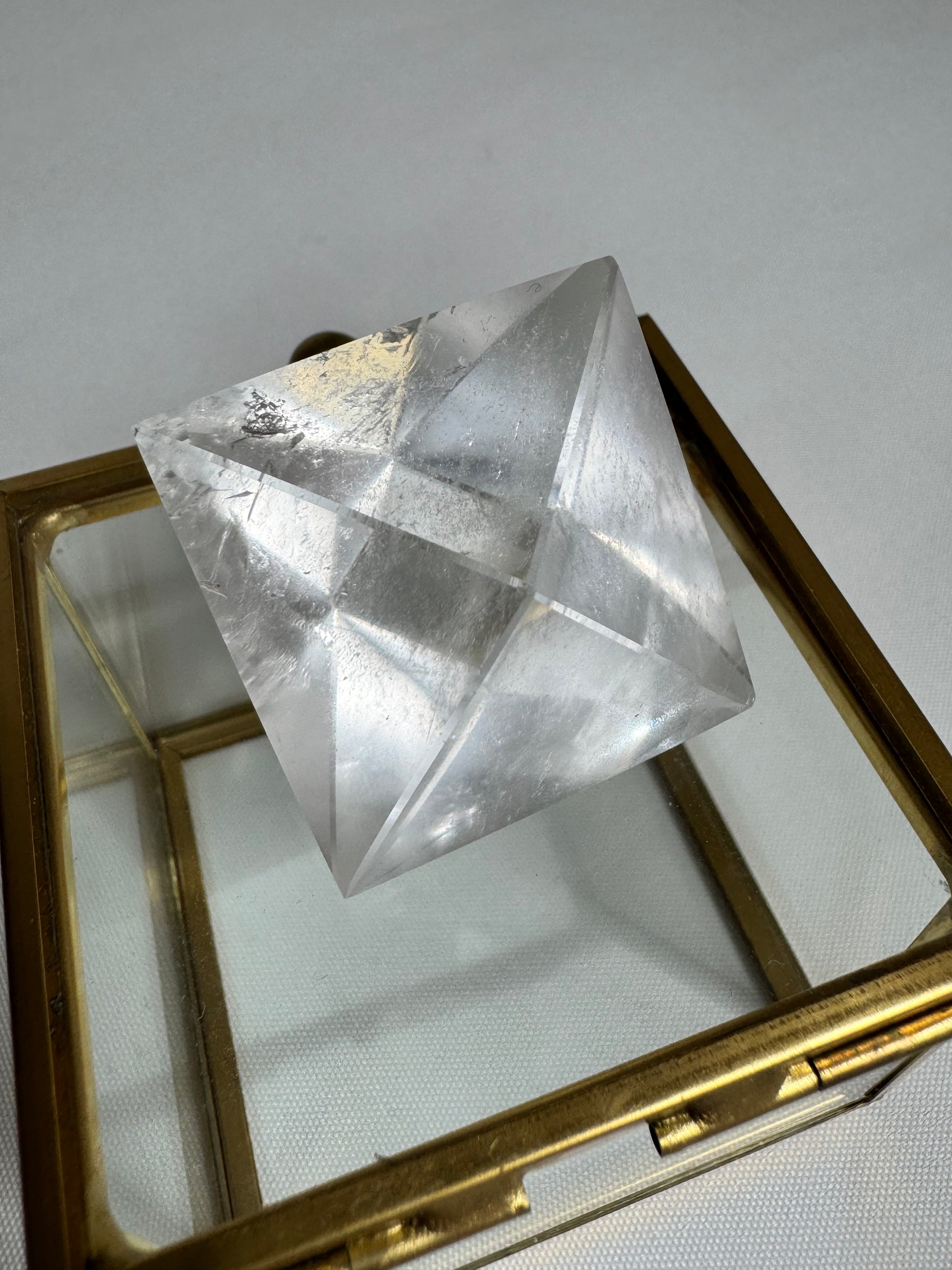 Large Lemurian Quartz Octahedron on glass box, perfect for energy healing and sacred geometry practices.