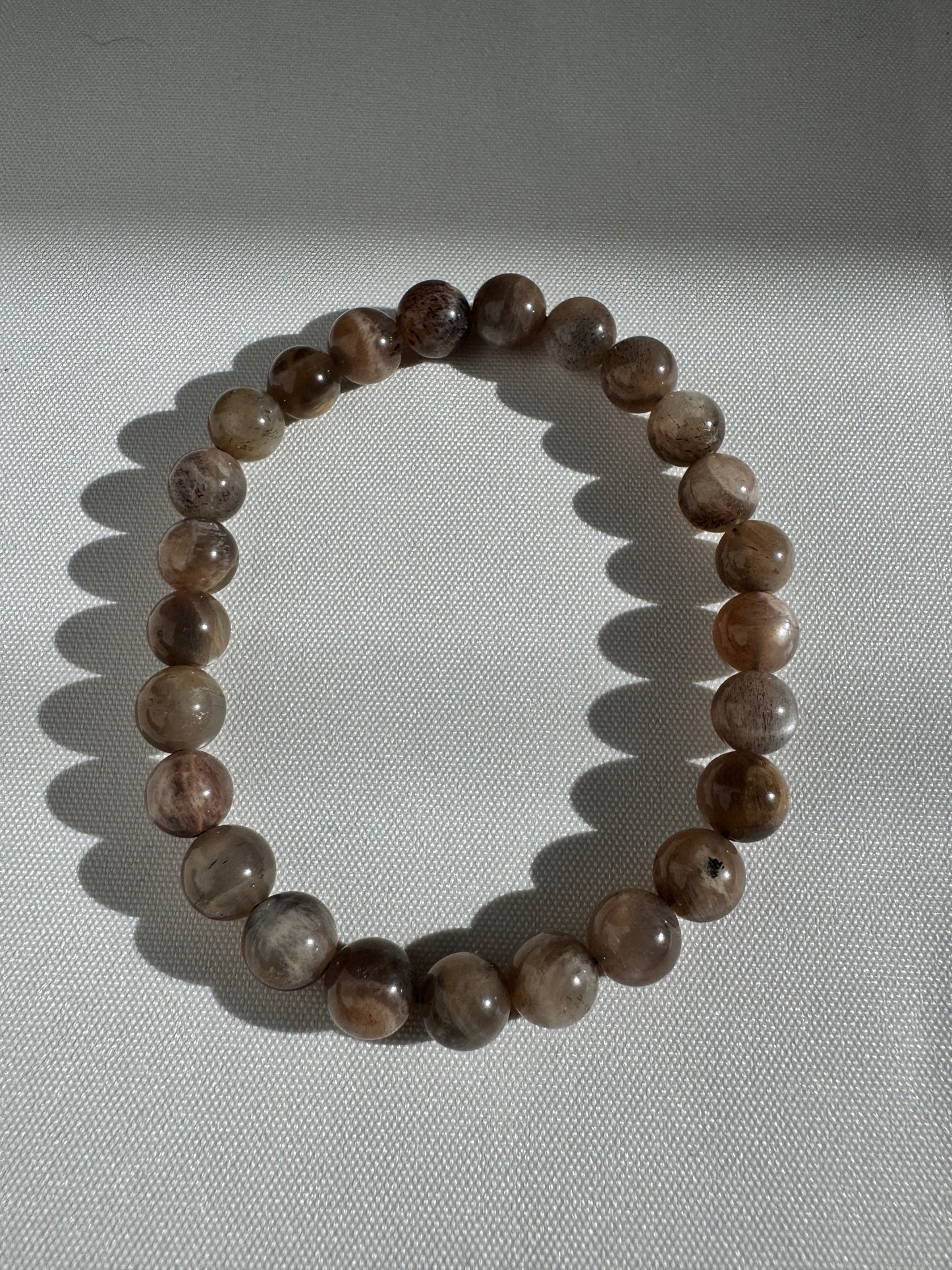 Single strand Peach Moonstone Bracelet with smooth round beads, designed for emotional balance and personal growth in jewelry collections.