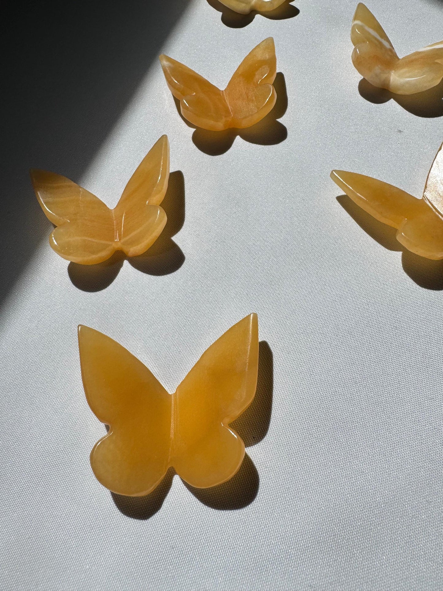 Group of Orange Calcite Crystal 3D Butterflies, showcasing their warm amber tones and smooth carved finish.