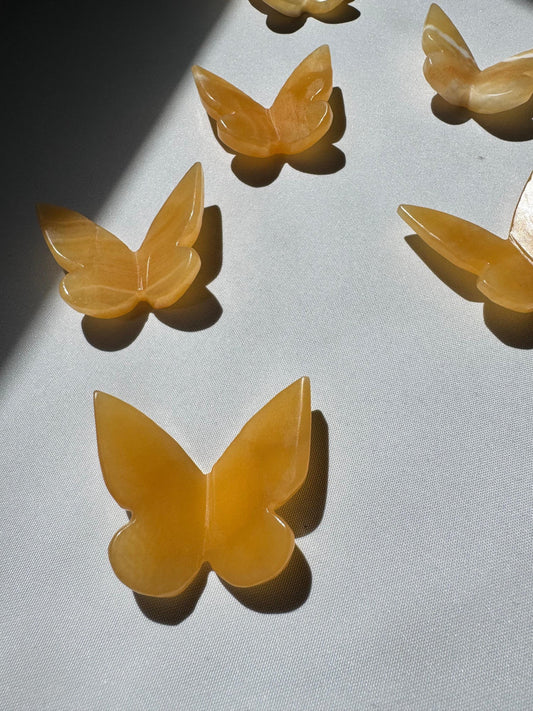 Group of Orange Calcite Crystal 3D Butterflies, showcasing their warm amber tones and smooth carved finish.