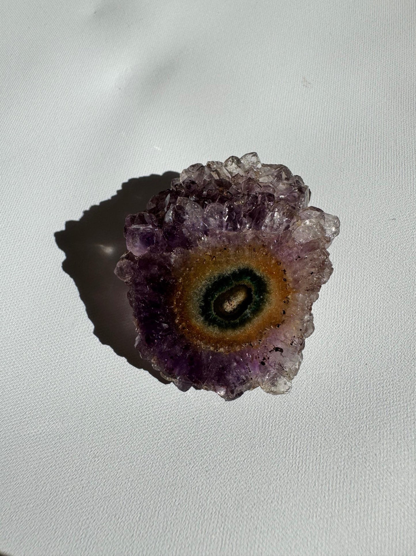 Round Amethyst Crystal Stalactite Grade A with green and amber center surrounded by violet crystals, perfect for metaphysical or decorative use.