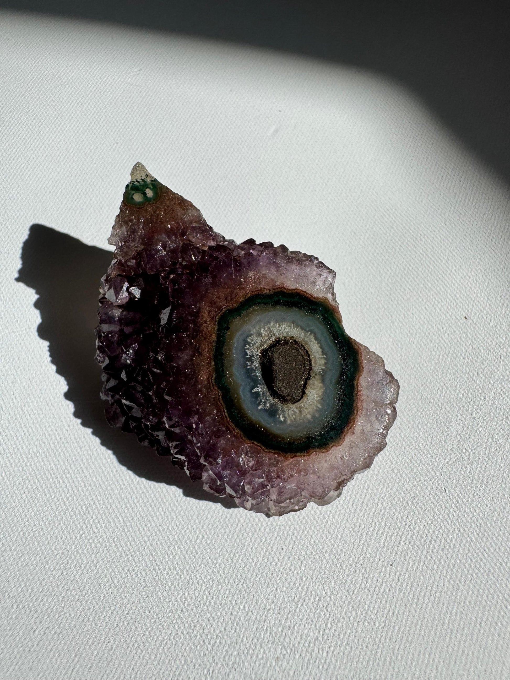Amethyst Crystal Stalactite Grade A with teal and green concentric rings, a naturally formed geode slice with artistic appeal.