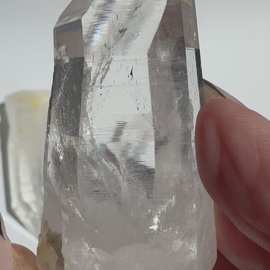 Close-up of Silver Light Lemurian Seed Point held in hand, highlighting its clarity and striations for spiritual healing and consciousness work.