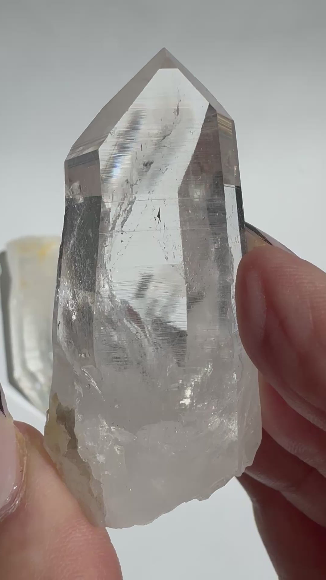 Close-up of Silver Light Lemurian Seed Point held in hand, highlighting its clarity and striations for spiritual healing and consciousness work.